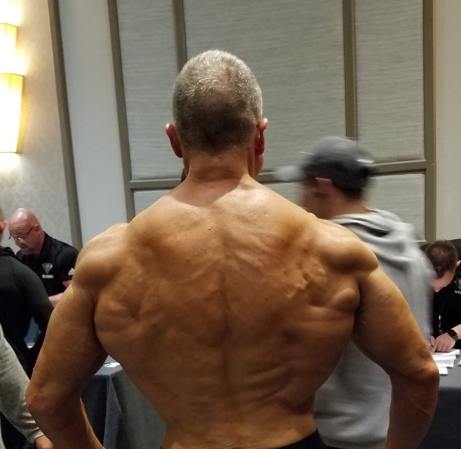 Dr. Cabrera back pose showcasing peak physical conditioning